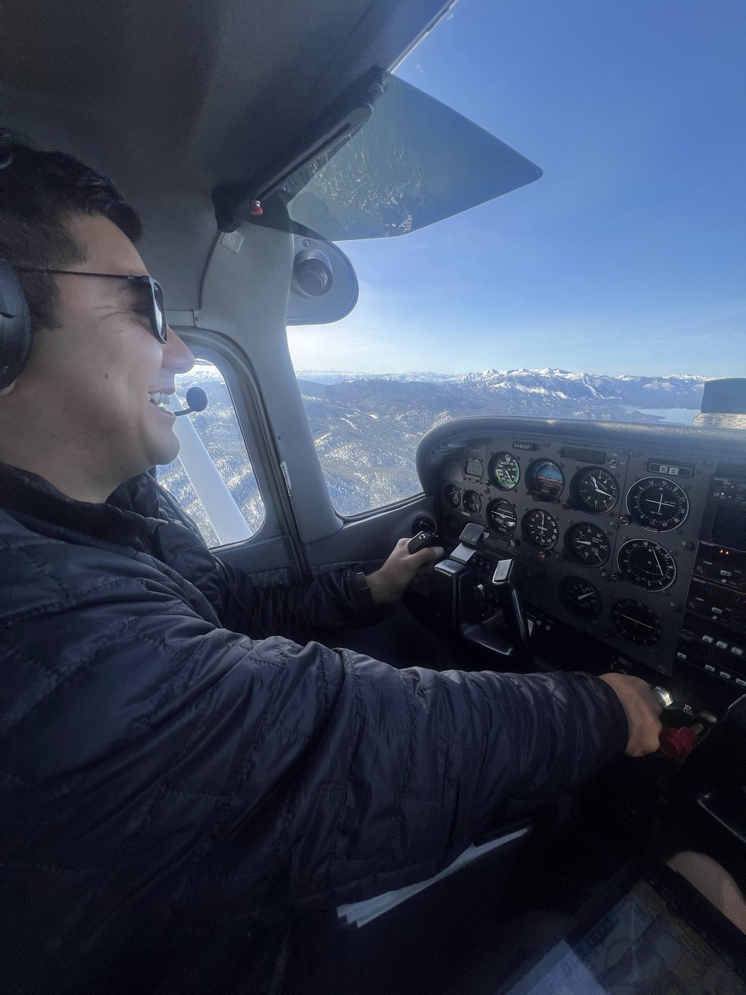 Rob Roderick (Robert Roderick), pilot, at the controls of a Cessna over the snowy Sierra Nevada near Lake Tahoe